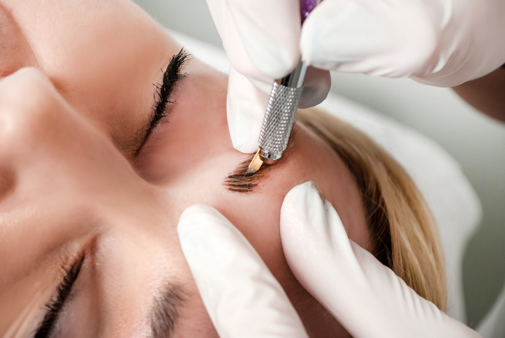 a brow technician doing eyebrow embroidery microblading for a customer